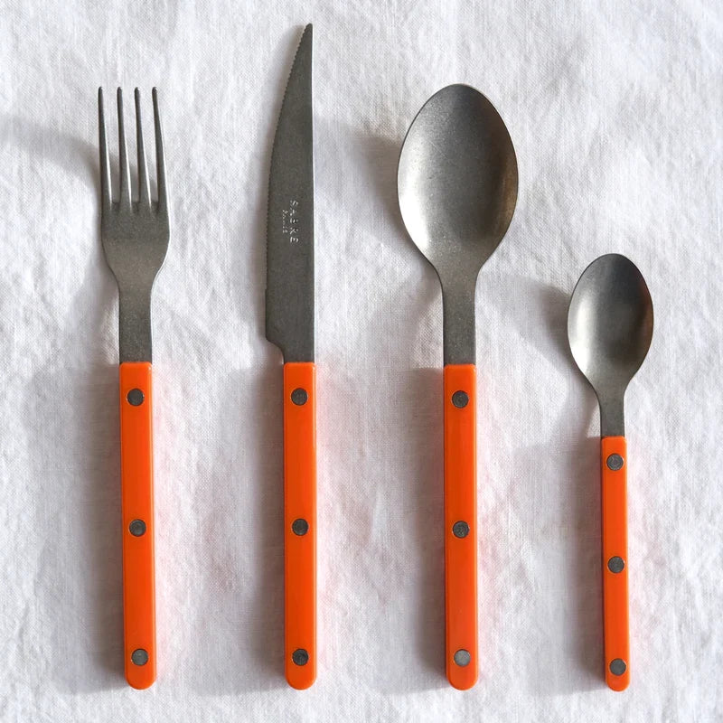 Sabre Paris Vintage Bistrot 4-piece cutlery set in orange, styled on table