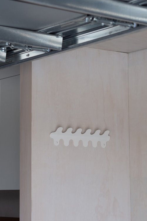 6 hook wiggle wall hanger in matt white, close-up detail