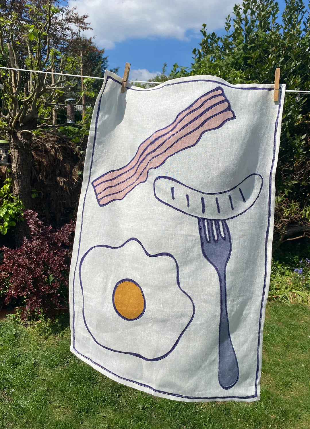 Eggs and bacon print linen tea towel, close-up of embroidery detail