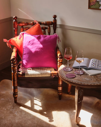 Amuse la Bouche 100% flax linen cushions. Orange and Fuchsia cushions edged with striped piping and bows. Feather inner included.